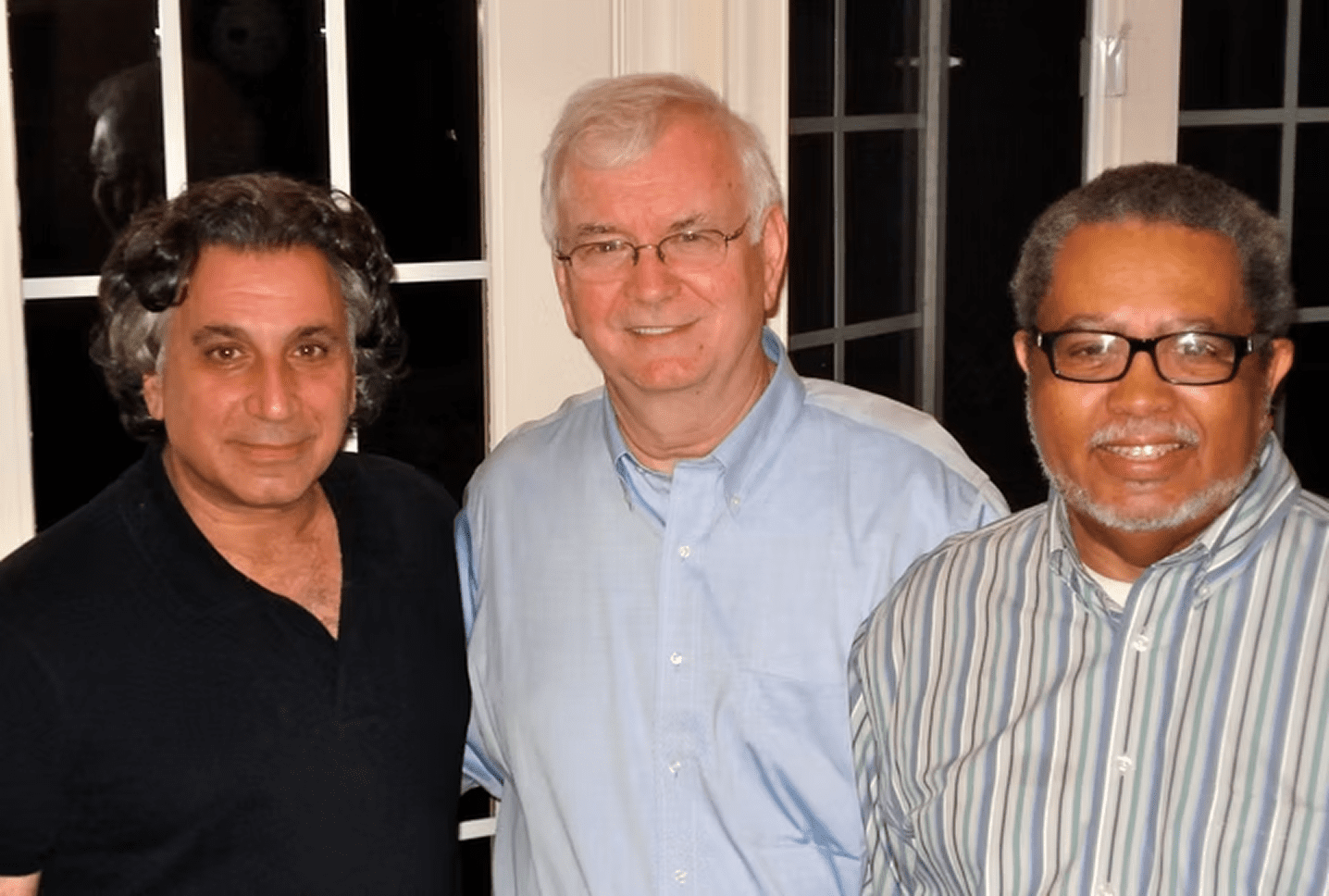 Three men posing indoors