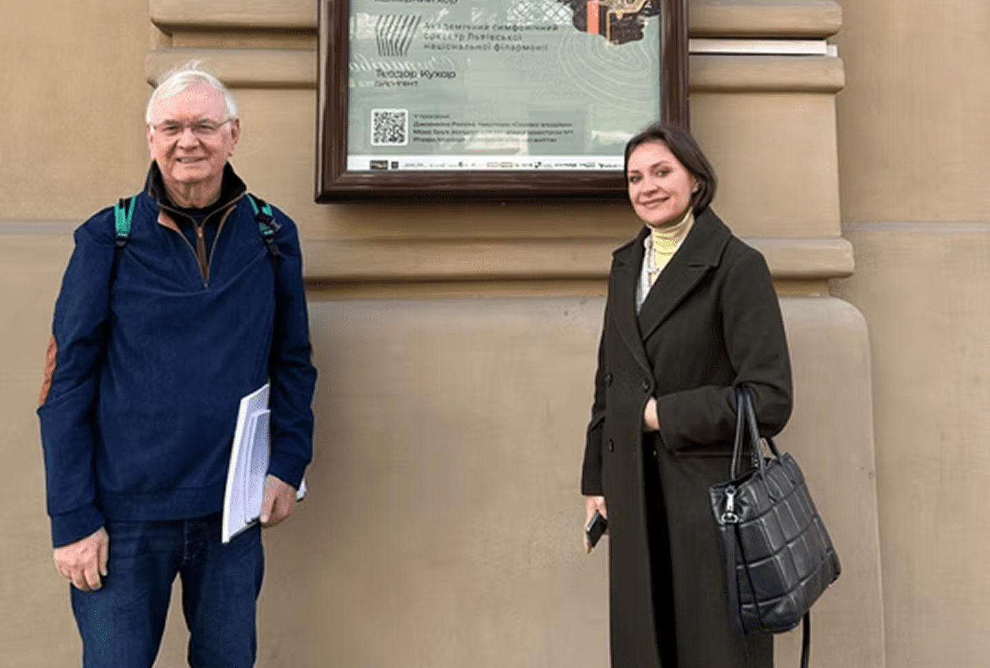 Man and woman posing near wall display