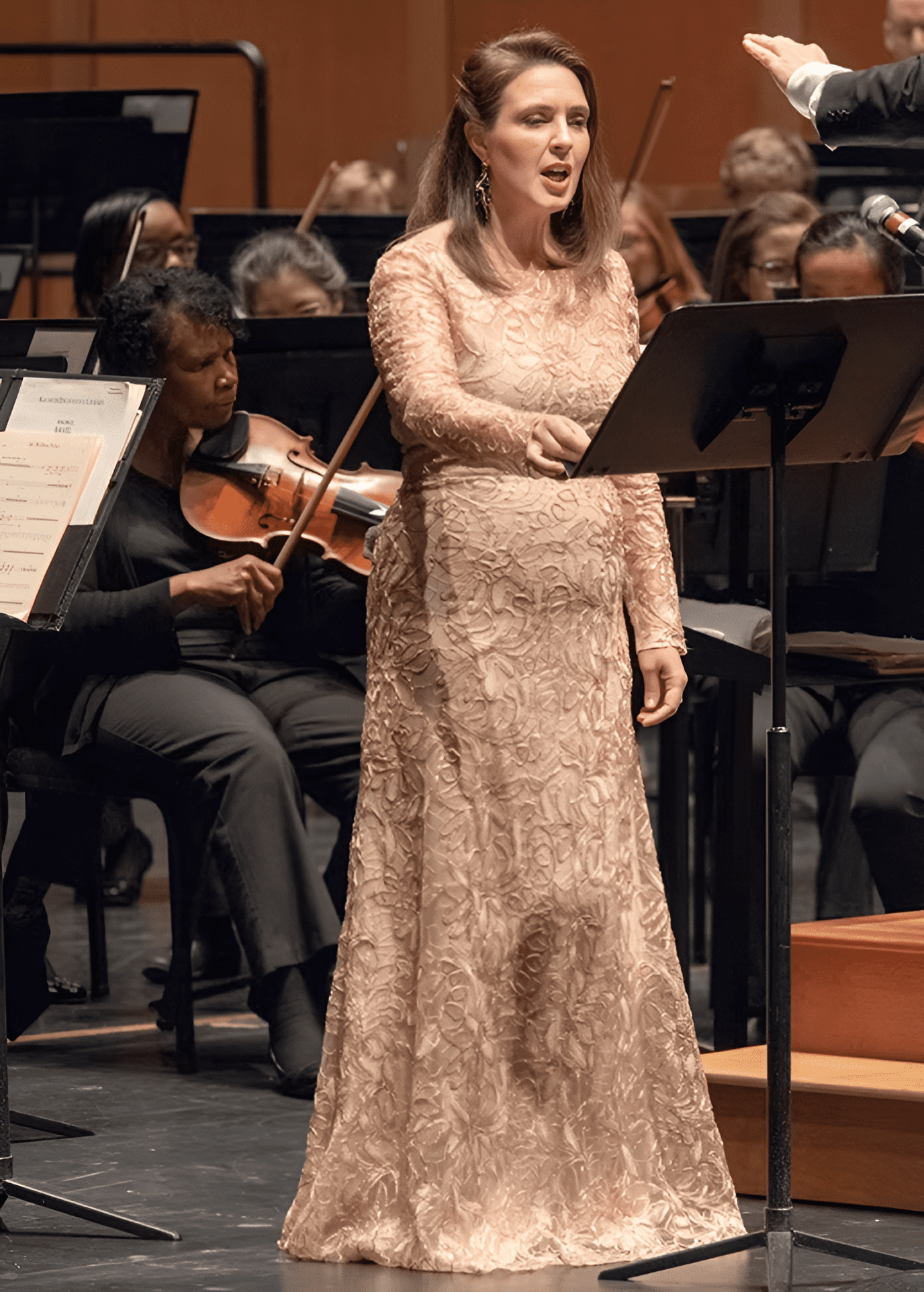 Woman singing on stage with orchestra